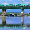 写真: 水鏡の鉄橋と石油コンテナ貨物