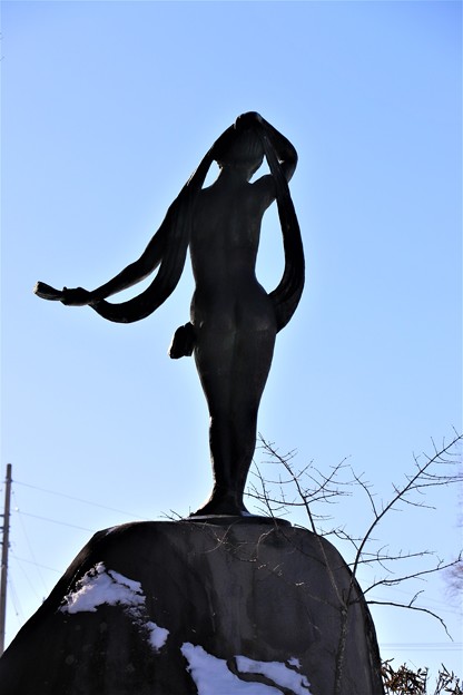 写真: 湖畔に建つ女神像シルエット