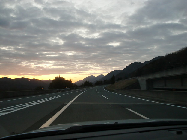 写真: 日が昇ってきた高速道路と山間の風景