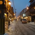 写真: 雪の降る街を