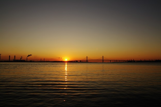 写真: 橋の端から陽が昇る。