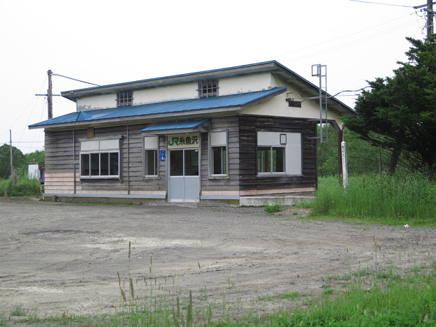 写真: 糸魚沢駅。のある板張りの木造駅舎。