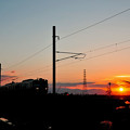 写真: 沈む夕陽と電車