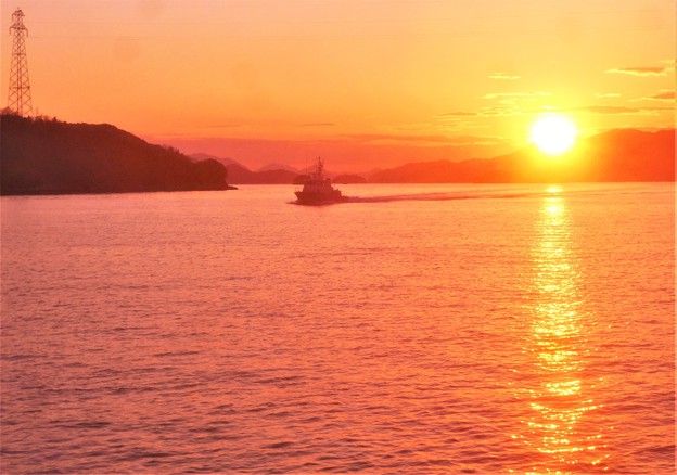 写真: 快走する からたち丸（海保CL71）と早春の夕陽＠瀬戸内海