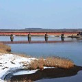 写真: 赤い鉄橋がある勇払川の風景