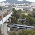 写真: 都会と自然が同居する場所を突き進む新幹線