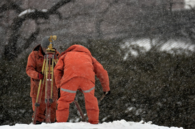 写真: 吹雪の中の測量作業
