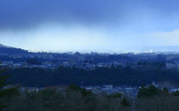 写真: 金沢市の街並みと雨雲