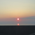 写真: 海に浮かぶ夕陽。